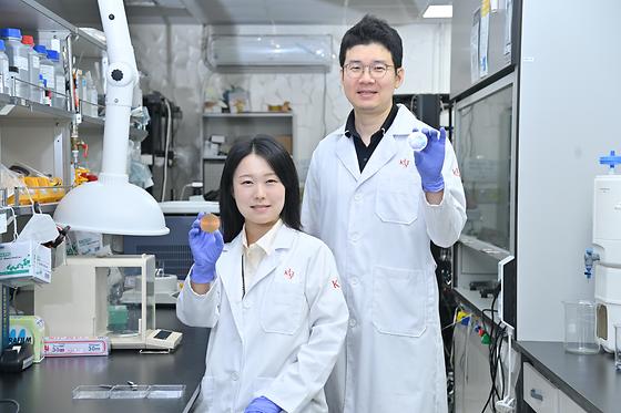 Postdoctoral researcher Minjeong Kim (left) and principal investigator Jin Gu Kang (right) show the colorful radiative cooling material they created in the process lab.